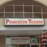 A sign for the princeton tuxedo store on a building.