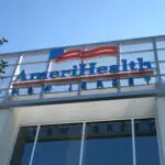 A sign for amerihealth pharmacy on the side of a building.