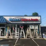 A store front with several ladders on the side of it.