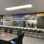 A conference room with chairs and tables in front of the wall.